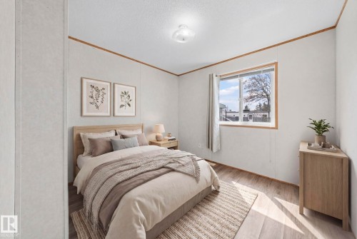 Light-filled room featuring wood-finish flooring, a neutral color palette, a ceiling-mounted light fixture, and a window with wood trim - 623 Evergreen Park, Edmonton, AB - Indoor Photo Showing Bedroom