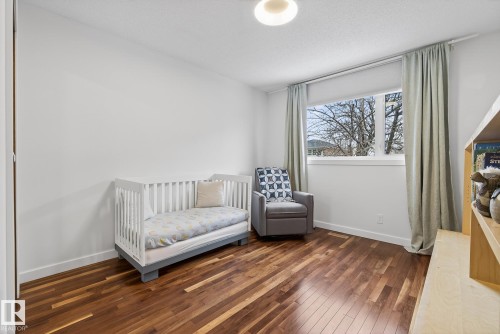 Room featuring hardwood floors, a large window, and light-colored walls - 9736 78 Avenue, Edmonton, AB - Indoor Photo Showing Bedroom