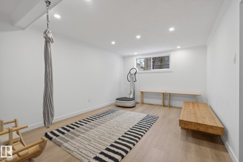 Versatile room with light wood-tone flooring, recessed lighting, and a window - 9736 78 Avenue, Edmonton, AB - Indoor