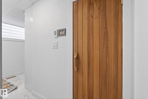 The property features a wood-paneled door with a matching wooden handle - 9736 78 Avenue, Edmonton, AB - Indoor Photo Showing Other Room