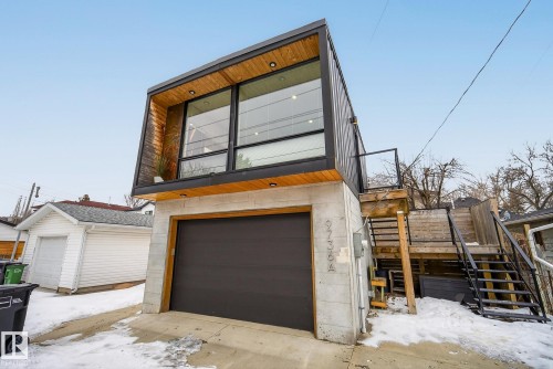Contemporary property featuring a garage, large windows, and an exterior staircase providing access to the upper level - 9736 78 Avenue, Edmonton, AB - Outdoor