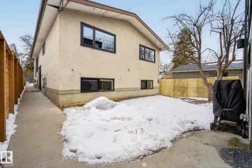 The property features an exterior with light-colored stucco siding and dark window frames - 9736 78 Avenue, Edmonton, AB - Outdoor