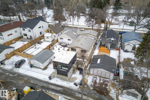 Aerial view of the property and its surrounding neighborhood, featuring a detached garage, a fenced yard, and a large deck - 9736 78 Avenue, Edmonton, AB - Outdoor