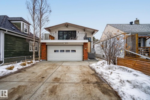 The property features a concrete driveway leading to an integrated two-car garage with a white sectional door - 9736 78 Avenue, Edmonton, AB - Outdoor