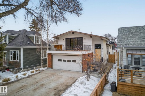 The property features a private drive, an integrated garage, and an upper-level balcony with a black metal railing - 9736 78 Avenue, Edmonton, AB - Outdoor