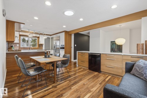 The kitchen and dining area feature rich hardwood flooring, recessed lighting, and a skylight - 9736 78 Avenue, Edmonton, AB - Indoor Photo Showing Dining Room