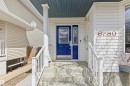 Front entry featuring a bright blue door with decorative glass inserts, white siding, and concrete steps - 8730 92A Avenue, Edmonton, AB  - Outdoor With Exterior 