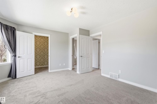 Light gray interior with soft carpeting, featuring white trim and baseboards - 8730 92A Avenue, Edmonton, AB - Indoor
