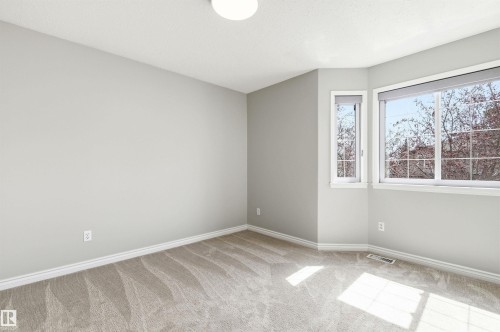 Room featuring light neutral wall paint, white trim, and light-toned carpet - 8730 92A Avenue, Edmonton, AB - Indoor Photo Showing Other Room