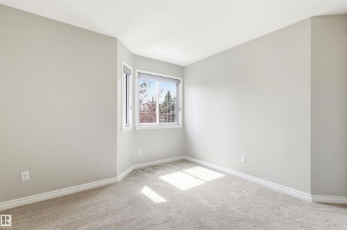 Carpeted interior room featuring light-toned walls and white trim - 8730 92A Avenue, Edmonton, AB - Indoor Photo Showing Other Room