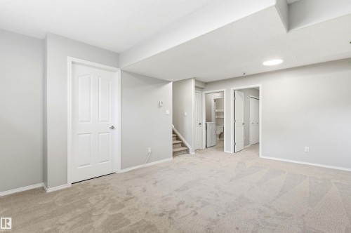 Spacious room featuring light gray walls, plush carpet flooring, white trim, and multiple doorways - 8730 92A Avenue, Edmonton, AB - Indoor Photo Showing Other Room