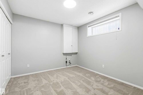 Carpeted room featuring light gray walls and a built-in white cabinet - 8730 92A Avenue, Edmonton, AB - Indoor Photo Showing Other Room