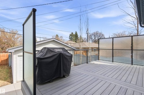 Spacious exterior deck featuring composite decking, black metal railings, and frosted privacy screens - 8730 92A Avenue, Edmonton, AB - Outdoor With Deck Patio Veranda With Exterior