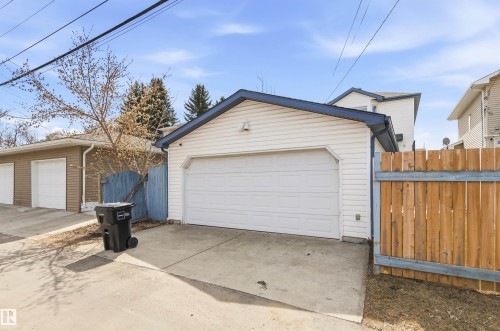 Detached garage with horizontal siding, a blue-trimmed roofline, and a concrete driveway - 8730 92A Avenue, Edmonton, AB - Outdoor With Exterior