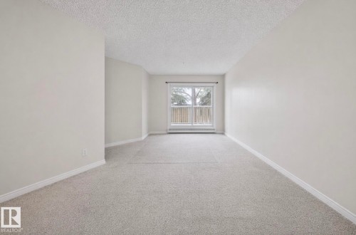 Neutral tone wall paint complements the light-colored carpeting - 103 12110 119 Ave, Edmonton, AB - Indoor Photo Showing Other Room