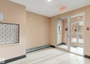 Lobby area featuring light-toned walls, white tile flooring, and a bank of mailboxes - 103 12110 119 Ave, Edmonton, AB  - Indoor Photo Showing Other Room 