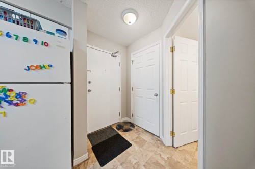 Entryway featuring light-toned flooring, white interior doors, and a ceiling-mounted light fixture - 103 12110 119 Ave, Edmonton, AB - Indoor Photo Showing Other Room