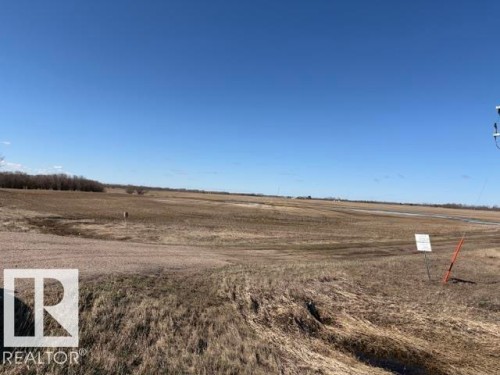 Expansive agricultural land featuring a clear horizon and distant tree lines under a bright blue sky - Hwy 38 Twpr 572 &574, Redwater, AB 