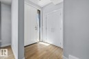 Entryway featuring a white paneled front door with a full-length sidelight, wood-finish flooring, and light gray wall paint - 8706 88 Avenue, Edmonton, AB  - Indoor Photo Showing Other Room 