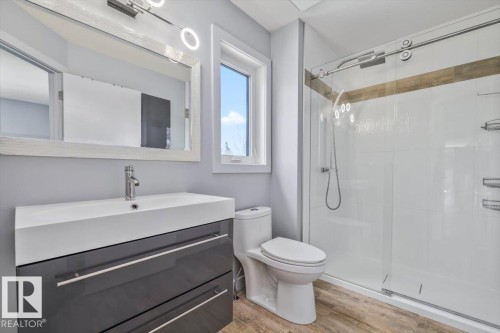 Bathroom featuring a floating vanity with integrated sink, chrome faucet, and glossy gray cabinetry - 8706 88 Avenue, Edmonton, AB - Indoor Photo Showing Bathroom