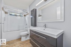 Bathroom featuring a vanity with an integrated sink, a wall-mounted medicine cabinet, and a framed mirror - 