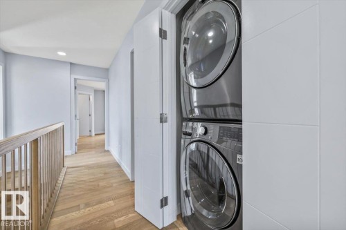 Integrated laundry closet featuring a stacked washer and dryer unit - 8706 88 Avenue, Edmonton, AB - Indoor Photo Showing Laundry Room
