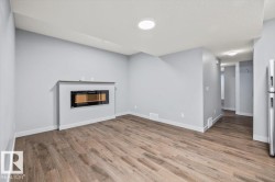 Living area featuring a sleek, wall-mounted electric fireplace with a floating mantel - 
