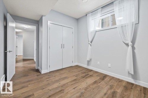 Room featuring wood-finish flooring, light gray wall paint, and white trim - 8706 88 Avenue, Edmonton, AB - Indoor Photo Showing Other Room