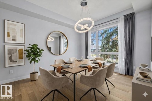 Bright dining area featuring a contemporary chandelier, wood-finish flooring, and a large window - 8706 88 Avenue, Edmonton, AB - Indoor Photo Showing Dining Room