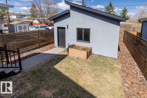 Detached structure with a sloped roofline, stucco exterior, and a solid black entry door - 8706 88 Avenue, Edmonton, AB - Outdoor With Exterior