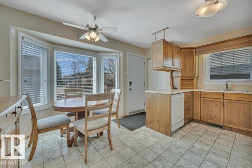 Kitchen with wood-finish cabinetry, light countertops, and an eat-in breakfast nook - 18227 76 Avenue, Edmonton, AB - Indoor