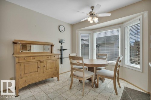 Bay window with white blinds, neutral wall tones, ceiling fan with light fixture, and light-toned tile flooring - 18227 76 Avenue, Edmonton, AB - Indoor Photo Showing Dining Room
