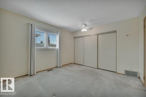 Carpeted room featuring a window with blinds, a ceiling fan, and sliding closet doors - 18227 76 Avenue, Edmonton, AB -  Photo Showing Other Room