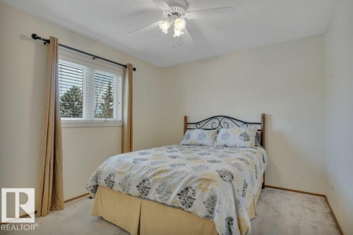 Bright room featuring a window with horizontal blinds, carpeted flooring, a neutral color palette, and a ceiling fan with integrated lighting - 18227 76 Avenue, Edmonton, AB - Indoor Photo Showing Bedroom