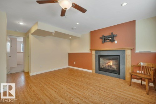 Spacious room featuring wood-finish flooring, a ceiling fan, and recessed lighting - 18227 76 Avenue, Edmonton, AB - Indoor Photo Showing Living Room With Fireplace