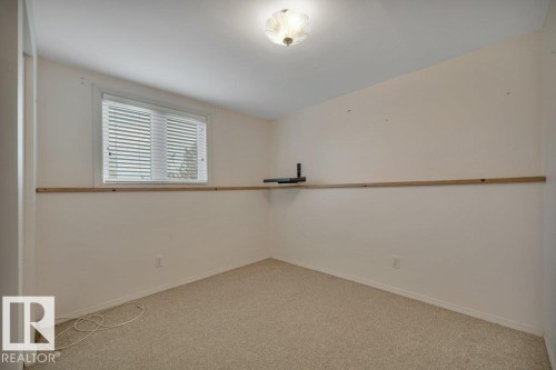 Neutral wall paint with a built-in wood shelf - 18227 76 Avenue, Edmonton, AB - Indoor Photo Showing Other Room