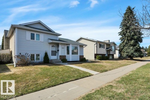 Split-level residence featuring light-colored siding and a dark shingle roof - 18227 76 Avenue, Edmonton, AB - Outdoor With Facade