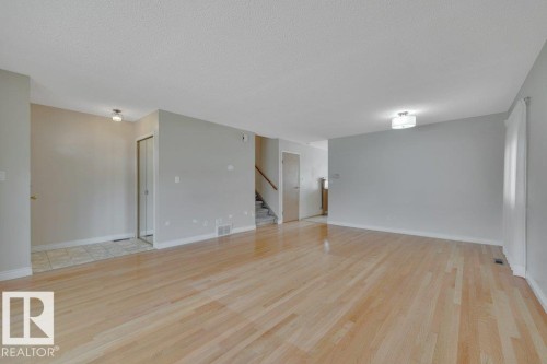 Spacious room featuring light wood-finish flooring, neutral wall tones, and ceiling-mounted lighting - 18227 76 Avenue, Edmonton, AB - Indoor Photo Showing Other Room