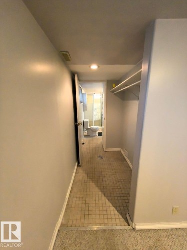 Hallway featuring neutral wall paint, overhead lighting, and built-in closet shelving - 10815 68 Avenue, Edmonton, AB - Indoor Photo Showing Other Room