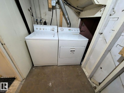 Utility area featuring a washer and dryer unit, exposed ceiling joists, and concrete flooring - 10815 68 Avenue, Edmonton, AB - Indoor Photo Showing Laundry Room