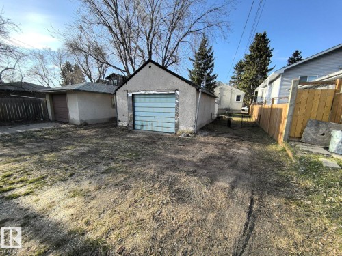 Detached garage with a light blue sectional door and a stucco exterior finish - 10815 68 Avenue, Edmonton, AB - Outdoor