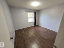 Spacious room featuring wood-finish flooring, light gray wall paint, and white baseboards - 10815 68 Avenue, Edmonton, AB  - Indoor Photo Showing Other Room 