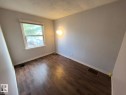 Wood-finish flooring, white baseboards, and a single window with white trim - 10815 68 Avenue, Edmonton, AB  - Indoor Photo Showing Other Room 