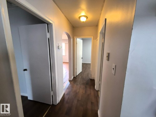 Hallway featuring wood-finish flooring, white painted walls, and a ceiling-mounted light fixture - 10815 68 Avenue, Edmonton, AB - Indoor Photo Showing Other Room