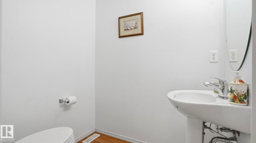 Pedestal sink with chrome faucet and white ceramic toilet - 80 287 Macewan Road, Edmonton, AB - Indoor Photo Showing Bathroom