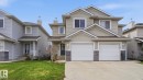 Multi-story residence featuring light-colored siding, a two-car garage with white doors, and a concrete driveway - 80 287 Macewan Road, Edmonton, AB  - Outdoor With Facade 