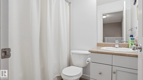 Bathroom featuring a built-in vanity with an undermount sink, a countertop, and cabinet storage - 80 287 Macewan Road, Edmonton, AB - Indoor Photo Showing Bathroom