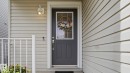 Entryway featuring a dark gray door with an upper window, white trim, and a contemporary wall light fixture - 80 287 Macewan Road, Edmonton, AB  - Outdoor With Exterior 