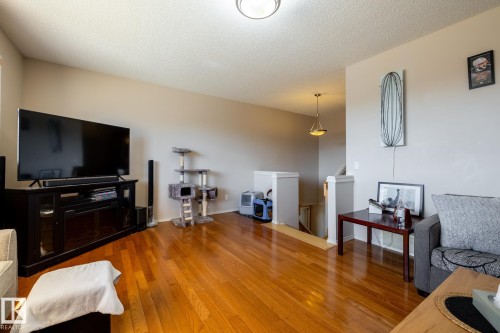 Open living area featuring wood-finish flooring, neutral wall tones, and recessed ceiling lighting - 55 Lamplight Cove, Spruce Grove, AB - Indoor