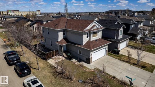 Two-story residence featuring light gray siding, a brown shingle roof, and an attached two-car garage with a white door - 55 Lamplight Cove, Spruce Grove, AB - Outdoor